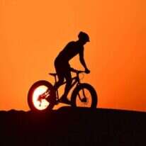 רוכב אופניים במדבר אל-קודרה בדובאי. | AFP רוכב אופניים במדבר אל-קודרה בדובאי. | AFP