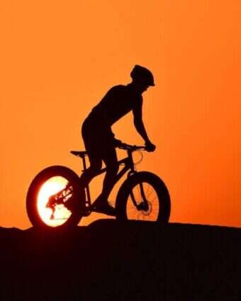 רוכב אופניים במדבר אל-קודרה בדובאי. | AFP רוכב אופניים במדבר אל-קודרה בדובאי. | AFP