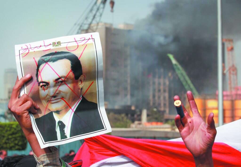 המאבטח המצרי אמר: "אינשאללה מובארק יסיים את תפקידו". שלט בכיכר תחריר, 2011. | גטי אימג'ס המאבטח המצרי אמר: "אינשאללה מובארק יסיים את תפקידו". שלט בכיכר תחריר, 2011. | גטי אימג'ס