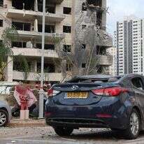 עם כלביא: בנין מגורים שנפגע במטח למרכז הארץ | AFP עם כלביא: בנין מגורים שנפגע במטח למרכז הארץ | AFP