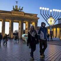 מטיילים ליד שער ברנדנבורג בחג החנוכה, ברלין, 19 בדצמבר 2020. | AFP מטיילים ליד שער ברנדנבורג בחג החנוכה, ברלין, 19 בדצמבר 2020. | AFP
