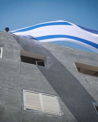 דגל ישראל מונף על בית שנפגע מטיל איראני | דוד כהן - פלאש 90 דגל ישראל מונף על בית שנפגע מטיל איראני | דוד כהן - פלאש 90