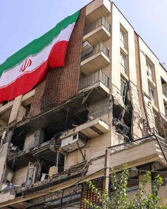 דגל איראן על בניין שנפגע בתקיפה של צה"ל | AFP דגל איראן על בניין שנפגע בתקיפה של צה"ל | AFP