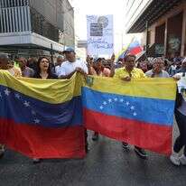 אזרחי ונצואלה עם דגל מדינתם | AFP אזרחי ונצואלה עם דגל מדינתם | AFP