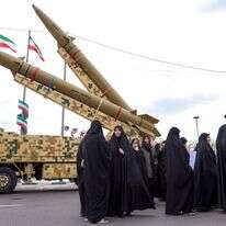 נשים הולכות ליד כלי שיגור טילים בליסטיים בטהרן ב-11 בפברואר 2026, במהלך עצרת לציון 47 שנה למהפכה האסלאמית ב-1979 | AFP נשים הולכות ליד כלי שיגור טילים בליסטיים בטהרן ב-11 בפברואר 2026, במהלך עצרת לציון 47 שנה למהפכה האסלאמית ב-1979 | AFP