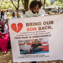 קרובי משפחה של אזרחים קנייתים שגויסו לצבא הרוסי באוקראינה מצטלמים עם תמונות של בני משפחותיהם | AFP קרובי משפחה של אזרחים קנייתים שגויסו לצבא הרוסי באוקראינה מצטלמים עם תמונות של בני משפחותיהם | AFP