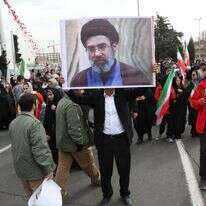 גבר איראני מחזיק תמונה של מוג'תבא חמינאי, בנו של המנהיג העליון של איראן, כשהוא משתתף בחגיגות 47 שנה למהפכה האסלאמית בטהרן | EPA גבר איראני מחזיק תמונה של מוג'תבא חמינאי, בנו של המנהיג העליון של איראן, כשהוא משתתף בחגיגות 47 שנה למהפכה האסלאמית בטהרן | EPA