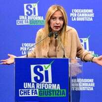 ראש ממשלת איטליה מלוני עם כרזת הקמפיין - שבו הפסידה במשאל העם | AFP ראש ממשלת איטליה מלוני עם כרזת הקמפיין - שבו הפסידה במשאל העם | AFP