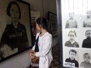 מבקרת מביטה על תמונות של קורבנות במתקן S-21. מבקרת מביטה על תמונות של קורבנות במתקן S-21.